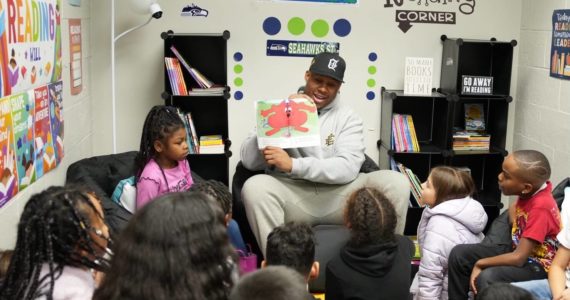 Uchenna Nwosu reads "Clifford Makes the Team" to kids at the Federal Way Boys and Girls Club on Dec. 5. Photo courtesy of the Seattle Seahawks