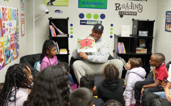 Uchenna Nwosu reads "Clifford Makes the Team" to kids at the Federal Way Boys and Girls Club on Dec. 5. Photo courtesy of the Seattle Seahawks