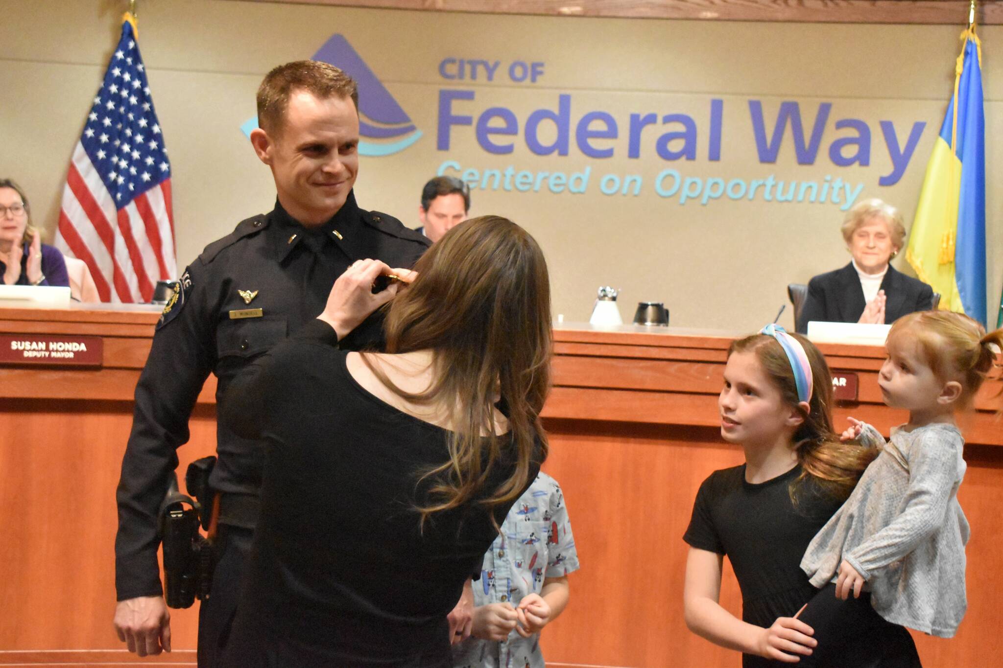 The family of Federal Way Police Officer Jeffrey Mundell pin his badge during his promotional swearing-in at the city council’s Jan. 17 meeting. Mundell was promoted from corporal to the lieutenant position. Alex Bruell / The Mirror