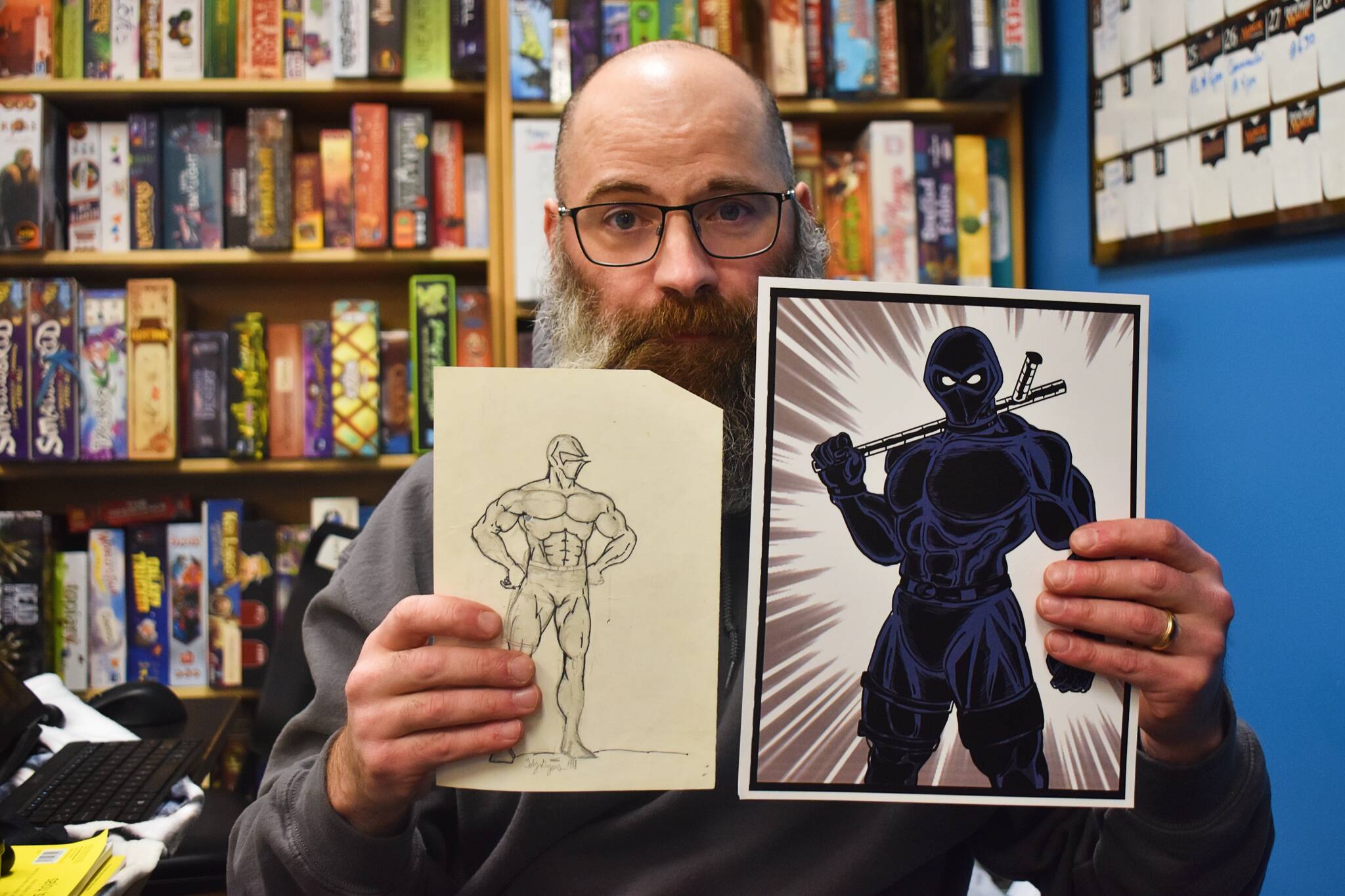 Toby Dycus holds up the oldest sketch of his character “Nightstik” next to a recent rendition. Alex Bruell / The Mirror