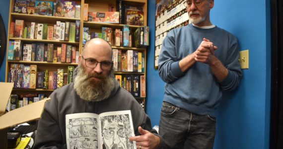 Toby Dycus (left) explains how he and co-writer Stephen Prescott put together one of the issues of “Nightstik.” Alex Bruell/The Mirror