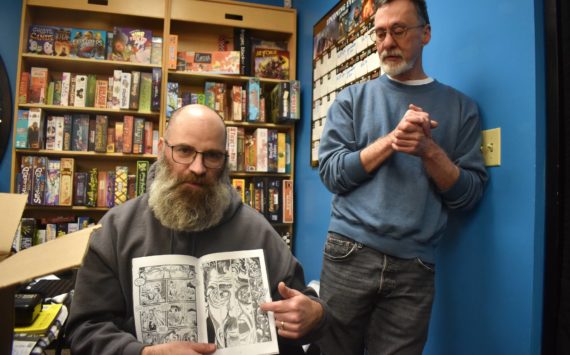 Toby Dycus (left) explains how he and co-writer Stephen Prescott put together one of the issues of “Nightstik.” Alex Bruell/The Mirror
