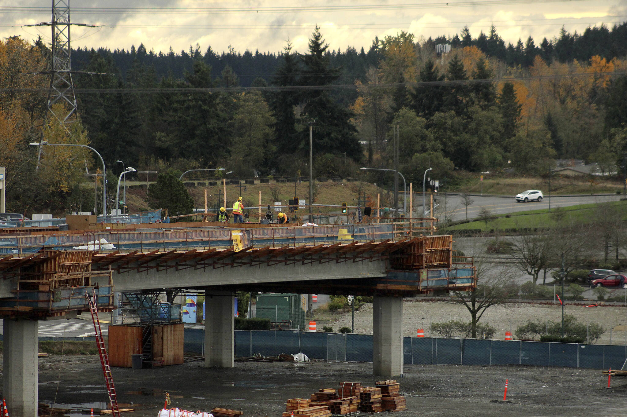 Construction workers work on the final stop of the Federal Way Link Extension light rail route along S. 320th Street in Federal Way on Nov. 19, 2021. Olivia Sullivan / the Mirror