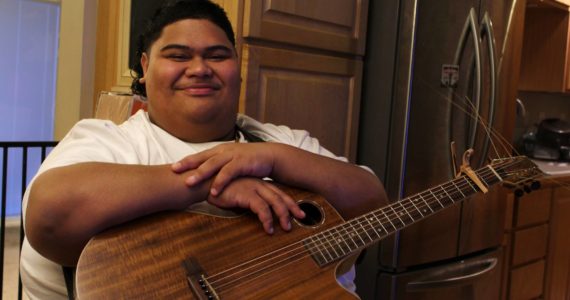 Decatur High School senior and “American Idol” contestant Iam Tongi sits at home on March 1. His father Rodney spent a bonus from his job as an electrician to buy Iam’s guitar. Alex Bruell / The Mirror