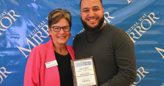 Federal Way Mirror Multi-Media Sales Manager Cindy Ducich stands with the Best Teacher - Middle School winner, Ahmad Tirhi of Sacajawea Middle School. Alex Bruell / The Mirror