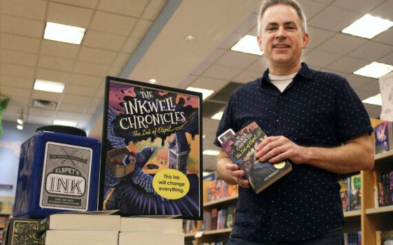 Alex Bruell / The Mirror 
JD Peabody holds a copy of his recently released book “The Ink of Elspet,” the first in his new series titled “The Inkwell Chronicles.” The books are for sale and on display at the Federal Way Barnes and Noble.
