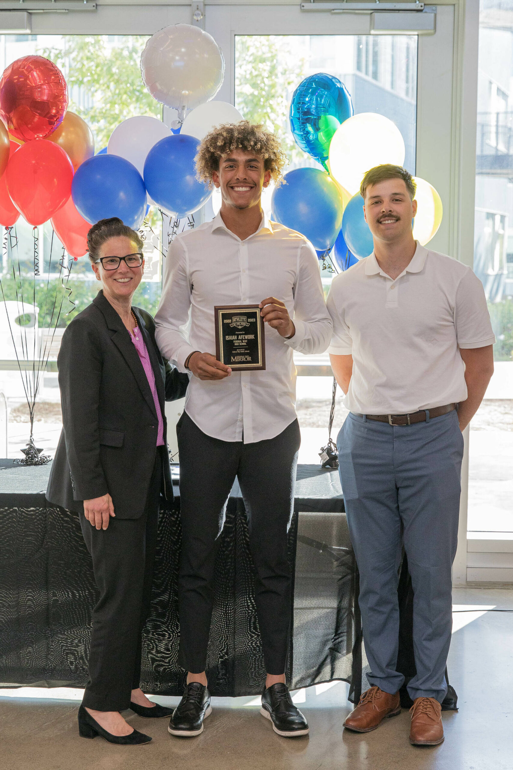 Eagle senior Isaiah Afework poses with Dr. Dani Pfeiffer and Mirror sports reporter Ben Ray. (Photo Provided by FWPS)
