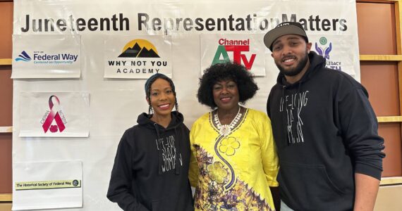 Marlie Love, Tirzah Idahosa and Anthony Love pose for a picture together in front of the Juneteenth event sponsors. (Photo by Joshua Solorzano/The Mirror)