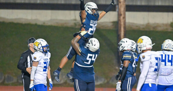 Jireh Ioane lifts up Nehemiah Washington after a touchdown. Photo by Dee Torres