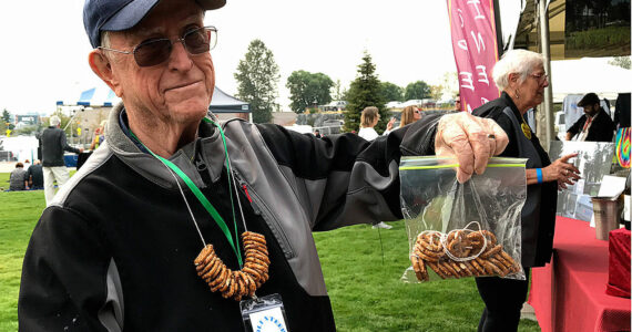 Federal Way Symphony volunteer Bob Kellogg sells pretzel necklaces at the Blues Festival held in 2017 at Town Square Park. (Mirror file photo)