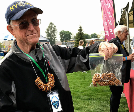 Federal Way Symphony volunteer Bob Kellogg sells pretzel necklaces at the Blues Festival held in 2017 at Town Square Park. (Mirror file photo)