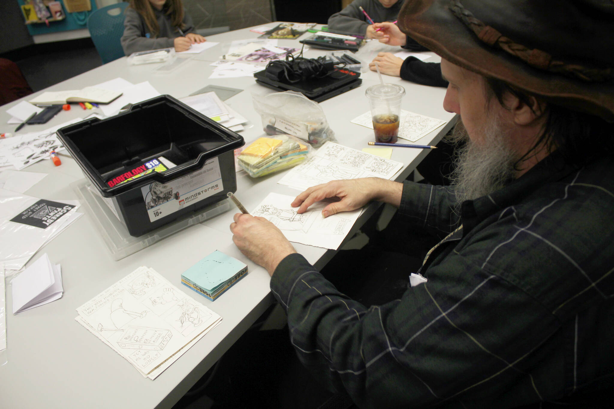 Alex Poorman works on a comic book during the zine class that he started creating during ComiCon last year. Photo by Keelin Everly-Lang / The Mirror
