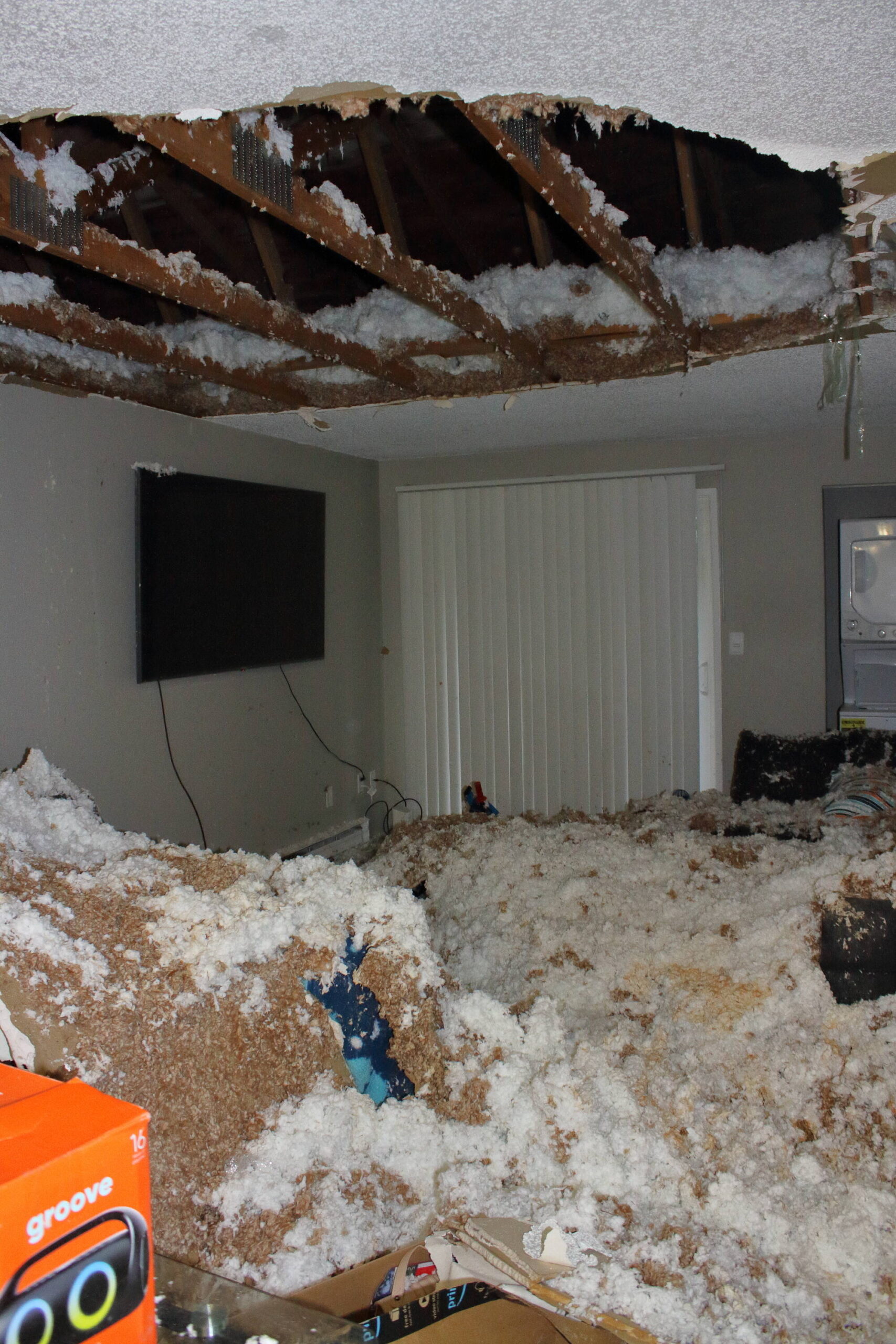 A resident at Miro Apartments arrived home to find her apartment covered in the insulation and ceiling detritus seen here. She has worked overtime to afford the furniture buried under the wreckage after fleeing a domestic violence situation. Photo by Keelin Everly-Lang / The Mirror.