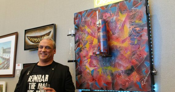 Reinhardt Hollstein is the creator of this unorthodox mixed-media painting, which depicts the fall of the Berlin Wall. Here he poses with the art piece at the first Arts Explosion Festival in 2023. Mirror file photo