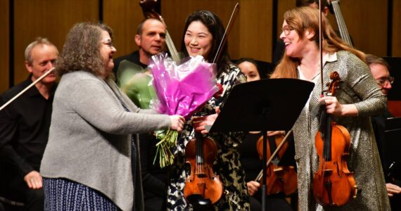 The recent Federal Way Symphony concert ends with a splash as flowers and accolades are shared. Photo by Bruce Honda.