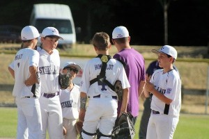 Steel Lake Little League 10/11 players talk with their coach during their June 24 game against Federal Way National.