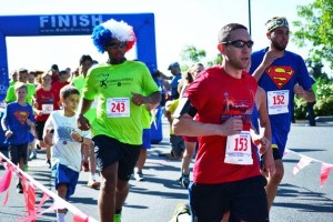 Runners cross the finish line during the annual Miles for Meso 5k in Federal Way on July 4.