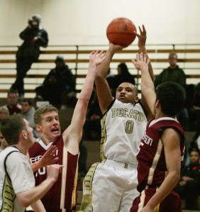 Decatur junior guard Dom Hunter goes up for a shot over Jefferson's Jacob Thoreson (left) and Daryon James during the Raiders' 71-61 win over the Gators Wednesday night in the opening round of the 2010 Bill Riley Communities Holiday Classic at Decatur.
