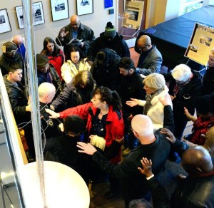 Dozens of people turn to one another and pray during a prayer rally on New Year's Eve at City Hall.