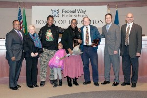Outgoing Federal Way Public Schools Board of Directors members Angela Griffin and Ed Barney (center) stand with current board members during the Dec. 10 board meeting.