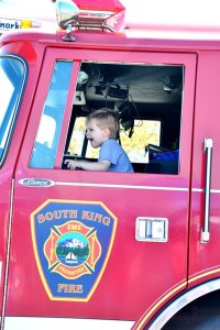 A child climbs aboard a South King Fire and Rescue engine during Family Safety Day at the Federal Way Farmers Market on Saturday.