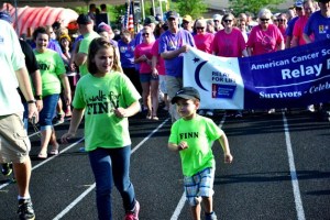 Young cancer survivor Finn (right) leads the first lap of the Federal Way Relay for Life on Friday evening at Saghalie Middle School.