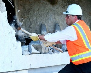 Federal Way Mayor Jim Ferrell sledgehammers a wall of the old Toys R Us building on Thursday morning