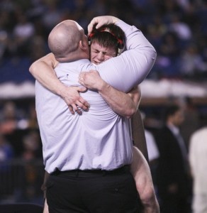 Thomas Jefferson senior Kyle McIntosh hugs Raider head coach Jess Workman after winning the 145-pound state championship inside the Tacoma Dome Saturday night.