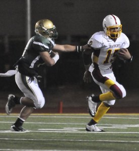 Thomas Jefferson senior quarterback K.W. Williams tries to escape an Auburn tackle Friday during the Raiders' 8-7 win over the Trojans at Federal Way Memorial Stadium. The win improves TJ to 2-1 on the season.