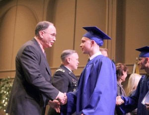 Cadet John Muralt of Thomas Jefferson High School shakes the hand during commencement proceedings on Dec. 19. Muralt spent the past six months living in Bremerton and will now return to Federal Way to finish his diploma.