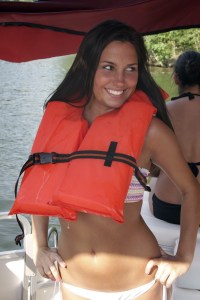 A woman wears an orange life jacket.