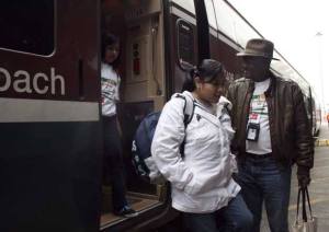 Eugene Montgomery helps children exit a train April 27 at the Tacoma Amtrak station as part of his KOSS program. The train ride rewards students for behaving and getting good grades.