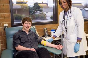 A Puget Sound Blood Center employee draws blood from a donor.