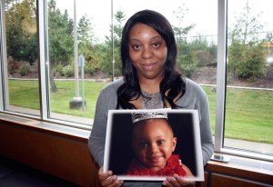 Amber Arrington holds up a photo of her daughter