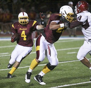Thomas Jefferson's Niko DelaCruz carries the ball behind Tim Luafatasaga during the Raiders' 49-34 loss to the Kentlake Falcons Friday night at Federal Way Memorial Stadium.