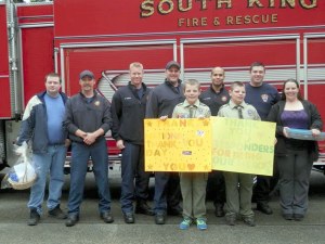 Boys Scouts Aidan and Shaun McCartney (holding signs) brought a basket of goodies to South King Fire and Rescue representatives on May 19 to thank them for their service.