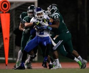 Federal Way senior quarterback Keenan Curran is tackled by Edmonds-Woodway defenders during Friday's 37-20 win by the Eagles. Curran had a pair of touchdown runs.