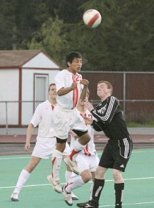 Jefferson junior Ernan Roman goes up for a header over a Kentwood defender Wednesday night at Federal Way Memorial Stadium. Kentwood won the game to take back first place from TJ. Both teams will play at the SPSL Tournament.