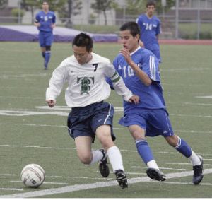 (Top) Beamer High School senior Daniel Nam (7) dribbles the ball against Bothell midfielder Yordan Rivera during the Titans’ 3-0 win over the Cougars Tuesday in the opening round of the Class 4A State Soccer Tournament in Sumner. (Below) Beamer freshman Ugo Okoli finished the game with an assist on a goal by Nam.