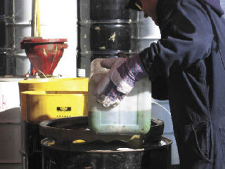 Hazardous waste is emptied into a barrel at a wastemobile event. Materials such as antifreeze will be collected July 11-13 in Federal Way. Photo courtesy of King County Solid Waste Division.