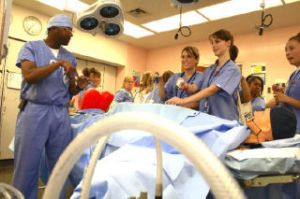 Ciera Madden and Tory Warshaw join students in a mock laproscopic surgery removing Skittles from a mannquin during the annual Nurse Camp.