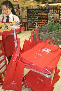 Top Foods in Federal Way displays its reusable bags in the front of its store. Pictured behind the bags is employee Regina Bartlotti.
