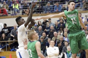 Federal Way’s Ferron Flavors puts up a shot over Woodinville’s Jesse Davis (right) and Ethan Tarbet (center) during Federal Way’s 79-64 win on Feb. 27 at Puyallup High School. Flavors finished with 31 points and made seven 3-pointers. TERRENCE HILL