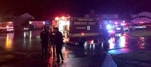 Police and aid personnel at the scene of a woman who was stabbed after opening the door to a trick-or-treater.