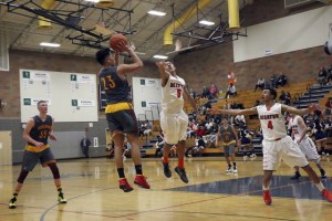 Thomas Jefferson’s Kobee Mendoza pulls up for a jump shot over Decatur’s Malik Eggleston during the first half of the Raiders 63-60 win on Monday at Todd Beamer High School. TERRENCE HILL