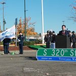 This 2014 photo shows Federal Way&rsquo;s mayor marking Veterans Day with the installation of the South 320th Street flag. This year, the Veterans Day event &lsquo;Honoring Our Own&rsquo; will be held Nov. 12 at Todd Beamer High School. RAECHEL DAWSON, file photo