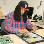 Geeks@Site part-time technician Aris Holcomb works to replace a broken computer motherboard with another at the business, 402 S. 333rd St., Suite B38, in The Agency Center Building. Co-owners Chris and Alice Stevenson, who are also husband and wife, opened the business six years ago.