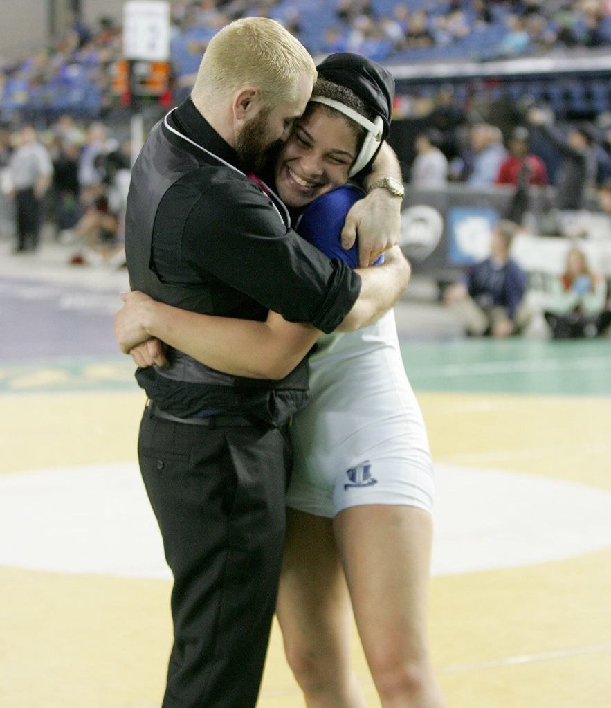 Federal Way girls wrestler Tally Thomas embraces Federal Way coach Travis Mango after winning her first state championship. Photo courtesy of Dennis Box