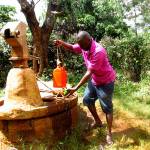 Samuel Irungu demonstrates what it would take to collect water from a well in Kenya during a visit to his home country last year. Courtesy of Samuel Irungu, World Vision