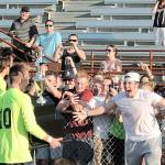 Top, Todd Beamer senior Austin Stafford carries the state championship trophy over to the Titans&rsquo; fan section after Beamer&rsquo;s 2-1 win over Pasco, Saturday. It was the school&rsquo;s first state title in any sport. Below, Beamer coach Joel Lindberg and senior Austin Stafford embrace one another moments after the Titans defeated the Pasco Bulldogs. JEROD YOUNG, the Mirror